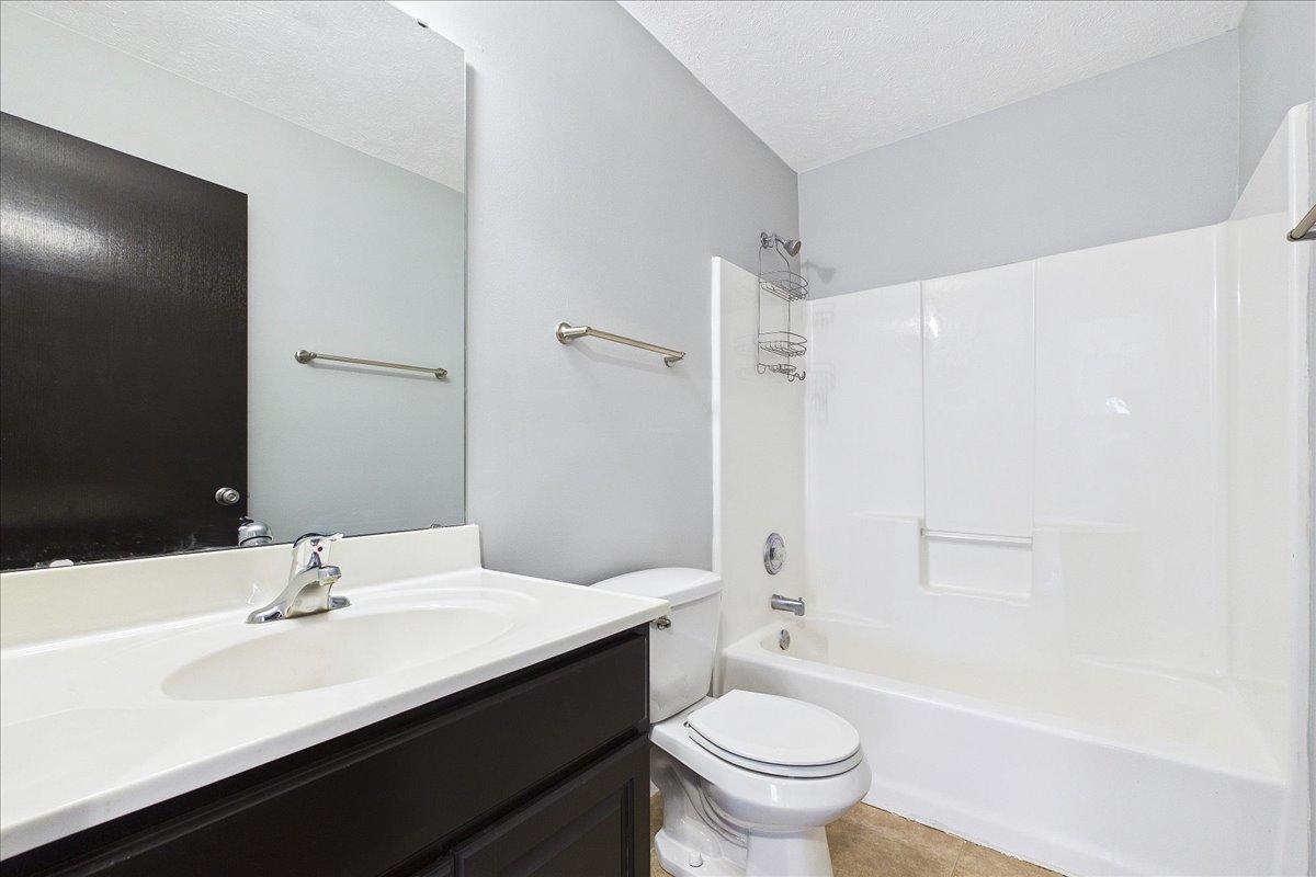 607 Clayton Circle, Unit 607 Sycamore, IL 60178 - Photo 19 of 48 a bathroom with a sink a toilet and a large mirror