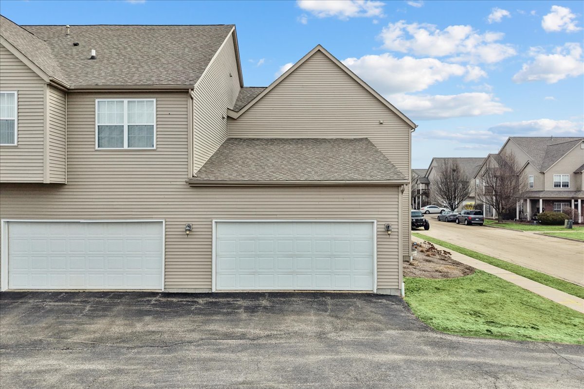 607 Clayton Circle, Unit 607 Sycamore, IL 60178 - Photo 27 of 48 a front view of a house with a yard and garage