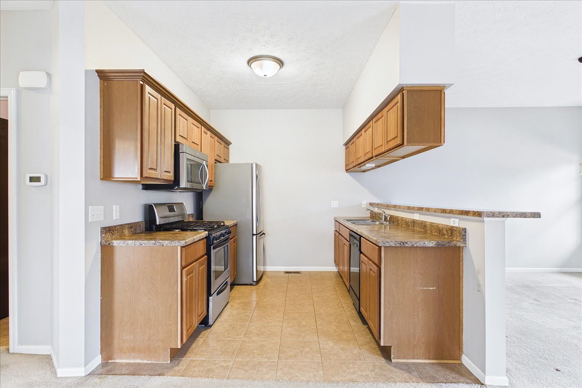 607 Clayton Circle, Unit 607 Sycamore, IL 60178 - Photo 8 of 48 a kitchen with stainless steel appliances granite countertop a stove a sink and a refrigerator