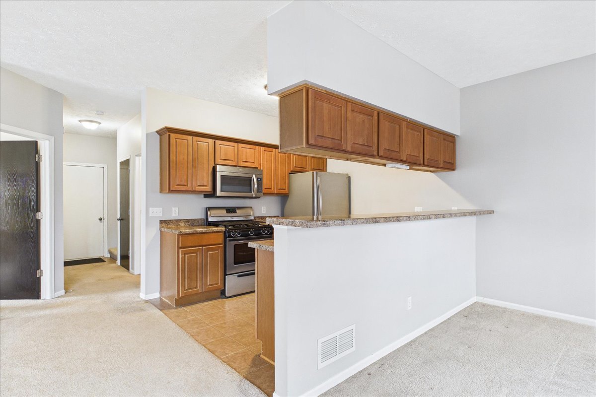 607 Clayton Circle, Unit 607 Sycamore, IL 60178 - Photo 9 of 48 a kitchen with stainless steel appliances granite countertop a refrigerator a stove and a sink
