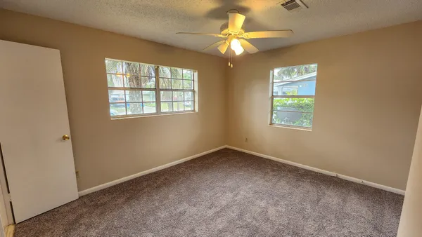 a view of an empty room with a ceiling fan