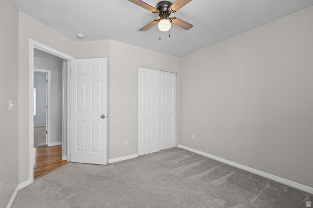 142 East 2675th Street South Clearfield, UT 84015 - Photo 24 of 49 Room featuring light gray wall paint, gray carpeting, a ceiling fan with light fixture, and white bi-fold closet doors