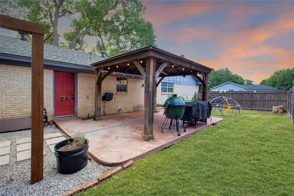 a view of a patio with a table and chairs under an umbrella with a sink