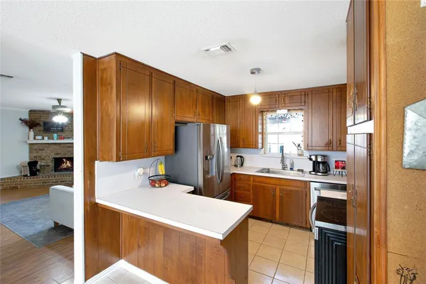 a kitchen with a refrigerator a stove and wooden floor