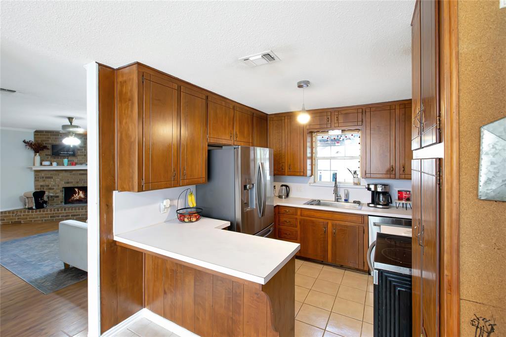853 Royal Terrace Hurst, TX 76053 - Photo 5 of 34 a kitchen with a refrigerator a stove and wooden floor