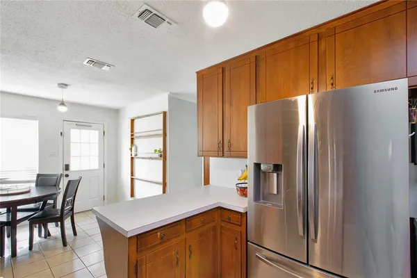 a kitchen with stainless steel appliances a refrigerator and wooden cabinets