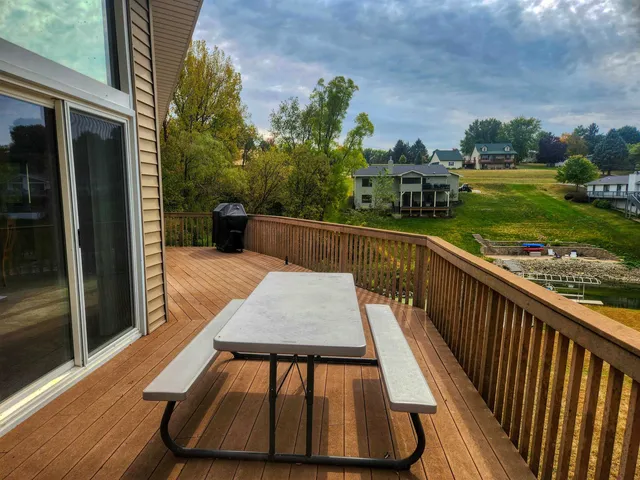 a view of a balcony with wooden floor and outdoor seating