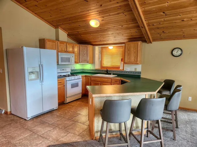 a kitchen with stainless steel appliances granite countertop a table chairs and a refrigerator
