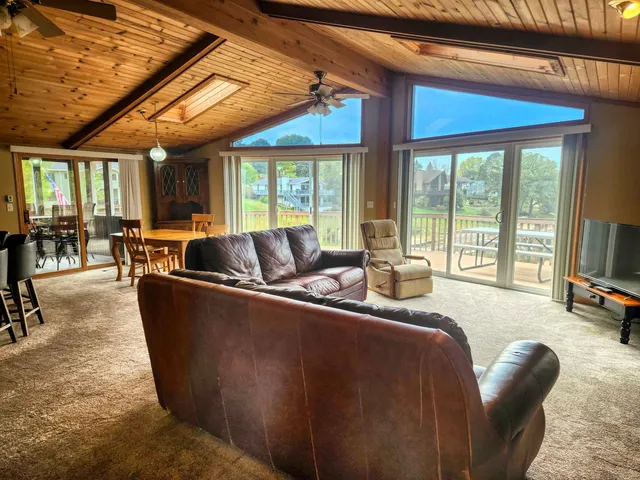 a living room with furniture a flat screen tv and large windows