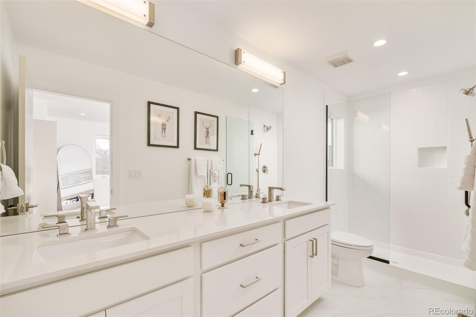 2357 South High Street Denver, CO 80210 - Photo 19 of 41 a bathroom with double vanity sink a mirror and a shower