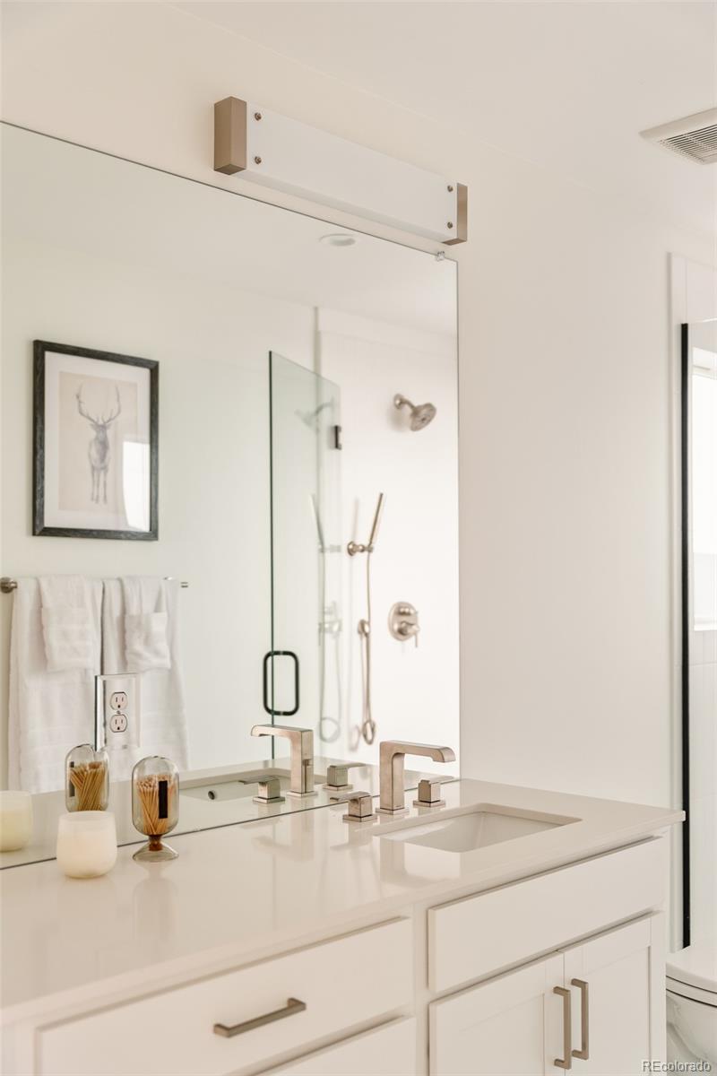 2357 South High Street Denver, CO 80210 - Photo 20 of 41 a bathroom with a double vanity sink and mirror