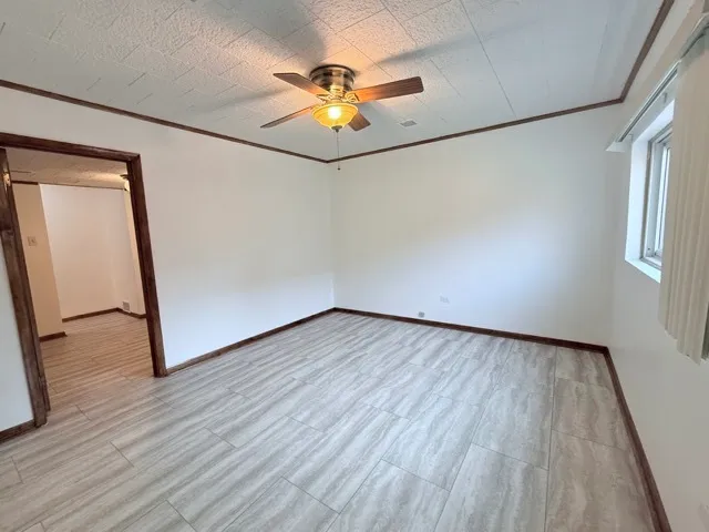 an empty room with wooden floor and chandelier