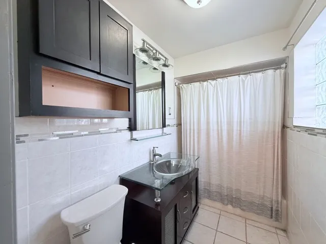 a bathroom with a granite countertop sink a toilet and a mirror
