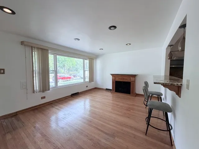 a view of a livingroom with furniture a fireplace and wooden floor