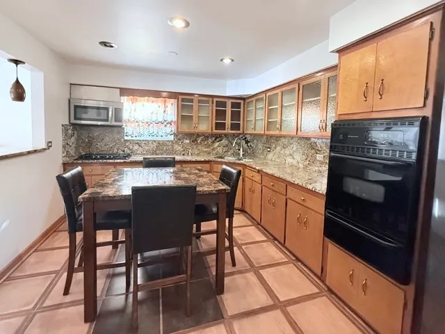 a kitchen with stainless steel appliances granite countertop a stove a sink and a refrigerator