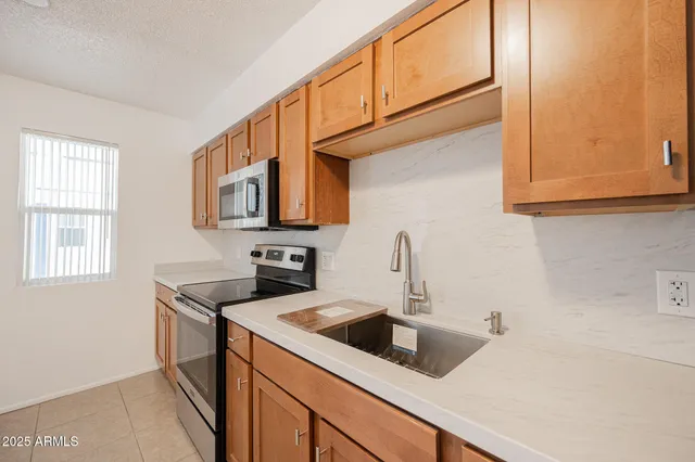 a kitchen with a sink cabinets and a window