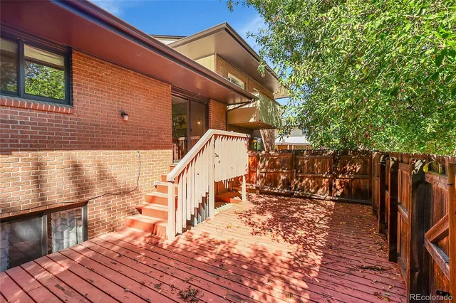 a view of deck with wooden floor and fence next to a yard