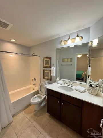 a spacious bathroom with a double vanity sink a toilet a bathtub and shower