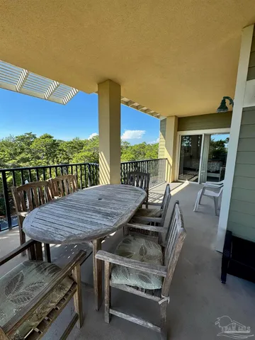 a view of a patio with table and chairs with wooden floor and fence