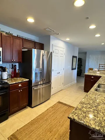 a kitchen with stainless steel appliances granite countertop a refrigerator stove and sink