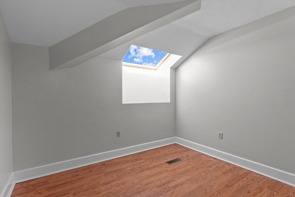 201 Thorndike Street, Unit 123 Lowell, MA 01852 - Photo 14 of 28 an empty room with wooden floor and windows