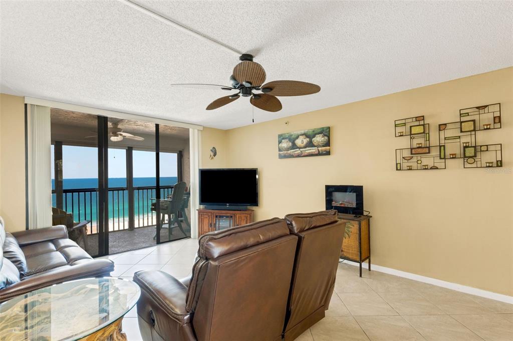 14900 Gulf Boulevard, Unit 410 Madeira Beach, FL 33708 - Photo 27 of 76 a living room with furniture a flat screen tv and a floor to ceiling window