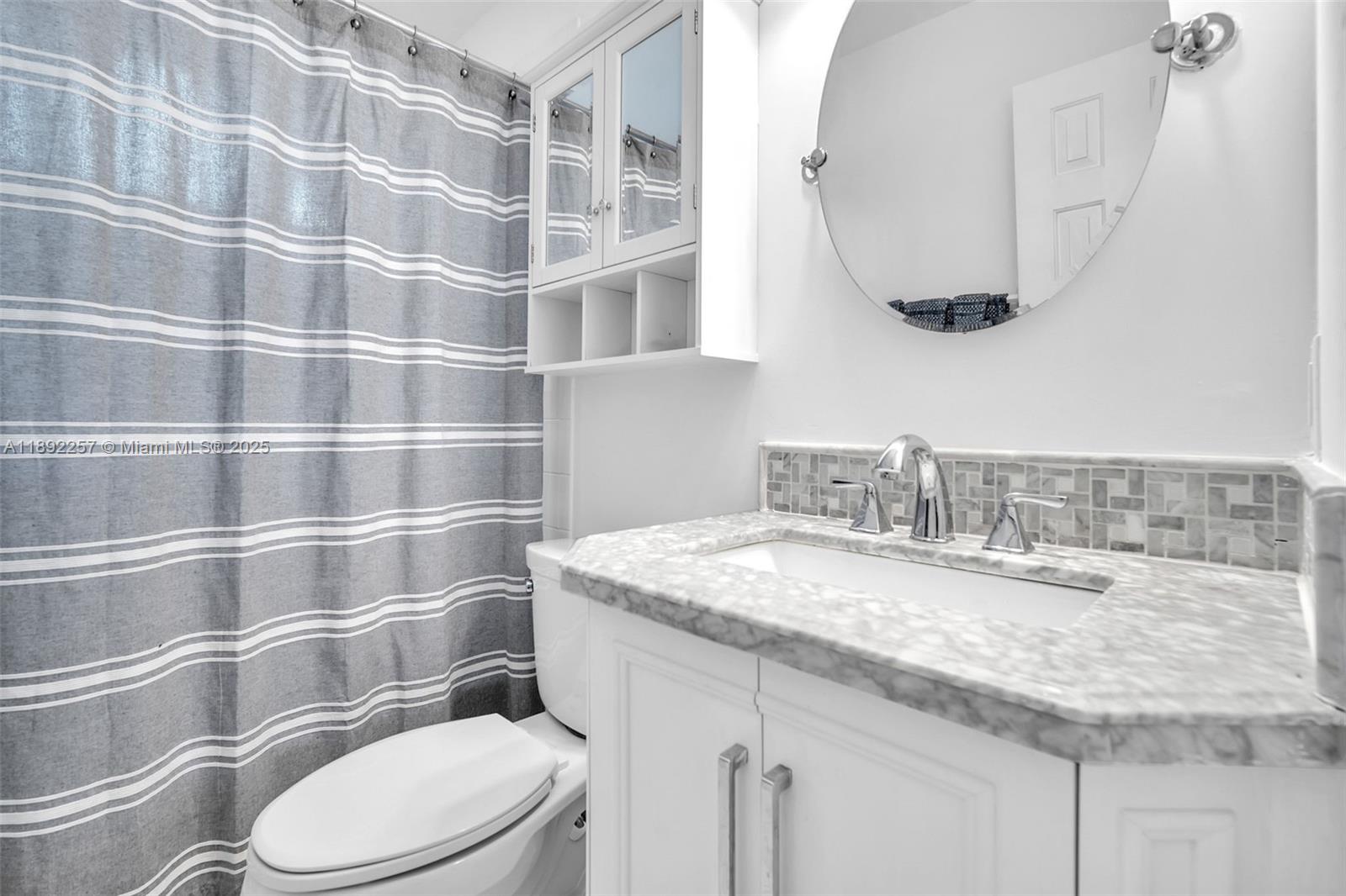 1637 Southwest 156th Avenue Pembroke Pines, FL 33027 - Photo 20 of 27 a bathroom with a granite countertop toilet sink and mirror