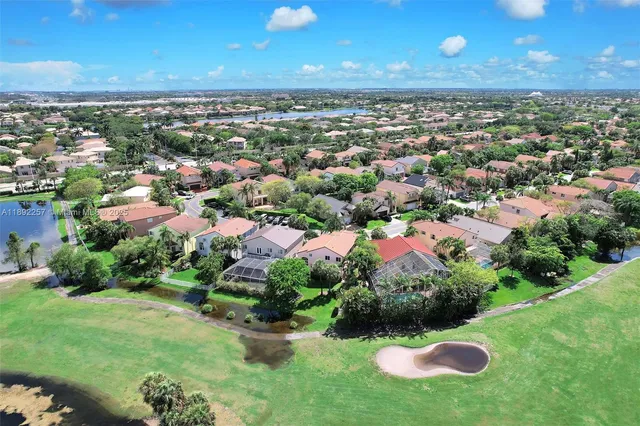 an aerial view of residential houses with outdoor space and trees