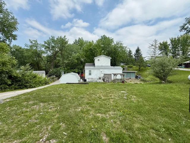 a view of a house with a yard and sitting area