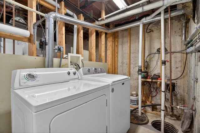 a view of a lake with lawn chairs and large trees