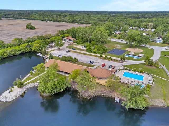 an aerial view of a house with a garden and lake view