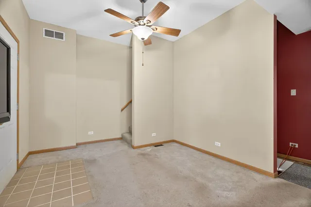 an empty room with a ceiling fan and a window