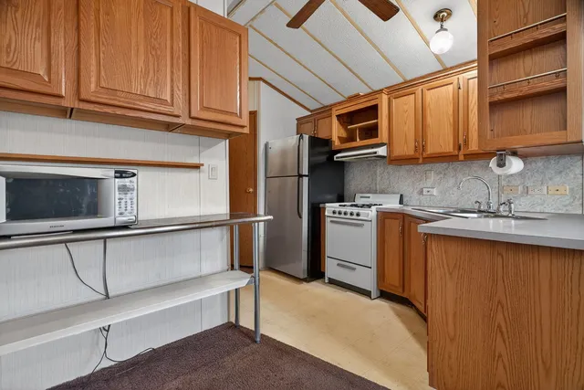 a kitchen with stainless steel appliances granite countertop a refrigerator and a sink