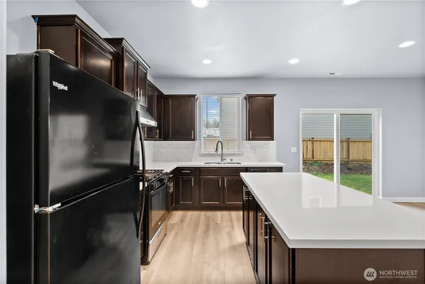 a kitchen with stainless steel appliances granite countertop a refrigerator a sink and a stove