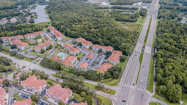 an empty room with chandelier fan and windows