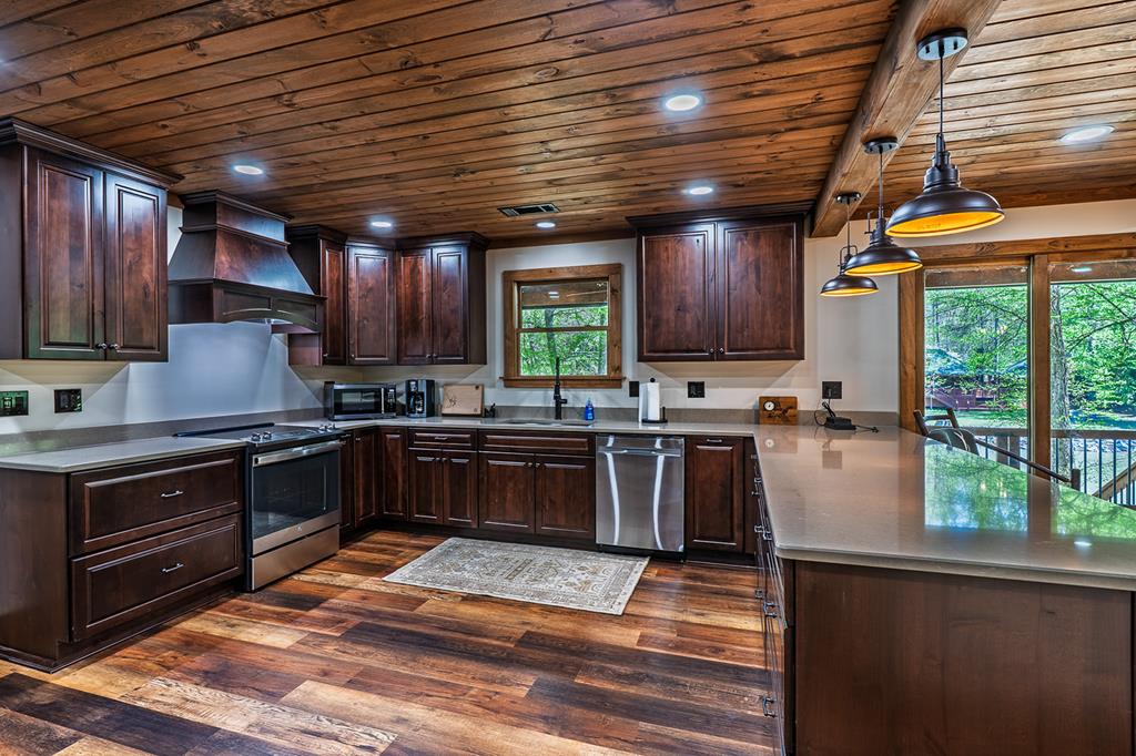 480 Riveredge Lane Ellijay, GA 30540 - Photo 23 of 66 a kitchen with granite countertop wooden cabinets stainless steel appliances a window and a counter space