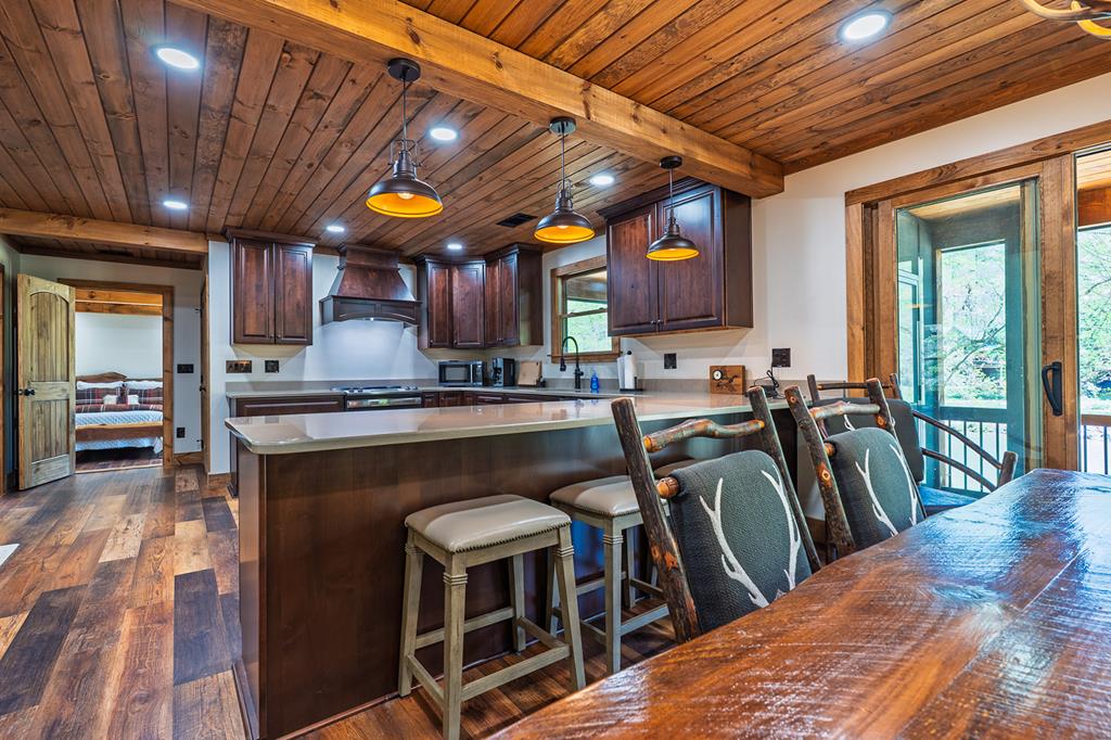 480 Riveredge Lane Ellijay, GA 30540 - Photo 41 of 66 a kitchen with stainless steel appliances granite countertop a stove a refrigerator a oven a sink with island chairs and wooden cabinets