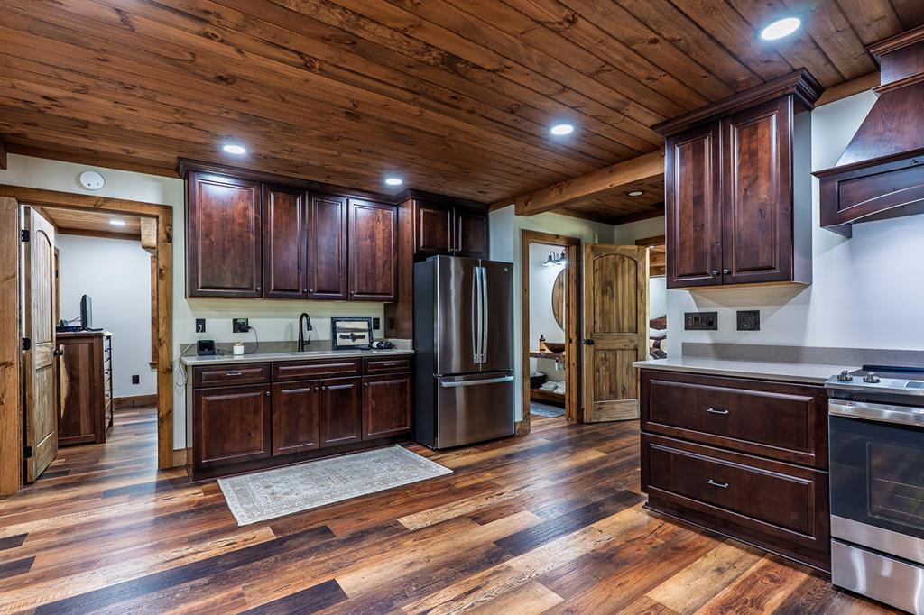 480 Riveredge Lane Ellijay, GA 30540 - Photo 43 of 66 a kitchen with stainless steel appliances granite countertop wooden floors wooden cabinets and sink