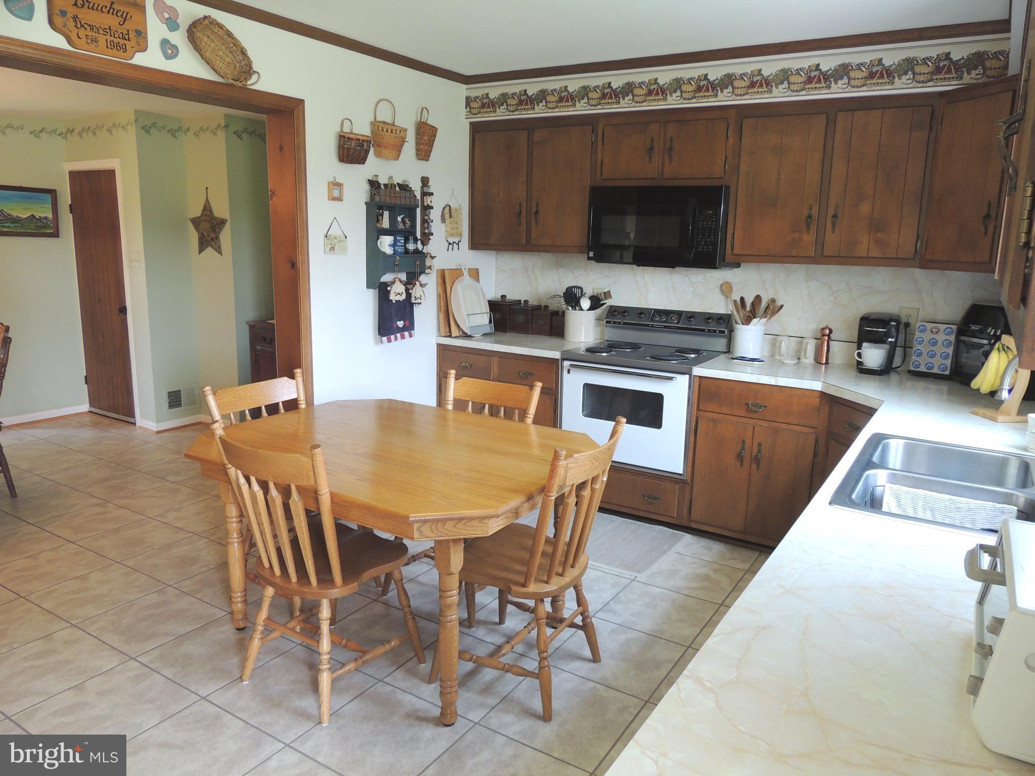 13730 Unionville Road Mount Airy, MD 21771 - Photo 7 of 30 a kitchen with stainless steel appliances a stove a sink dishwasher a refrigerator with a dining table and chairs