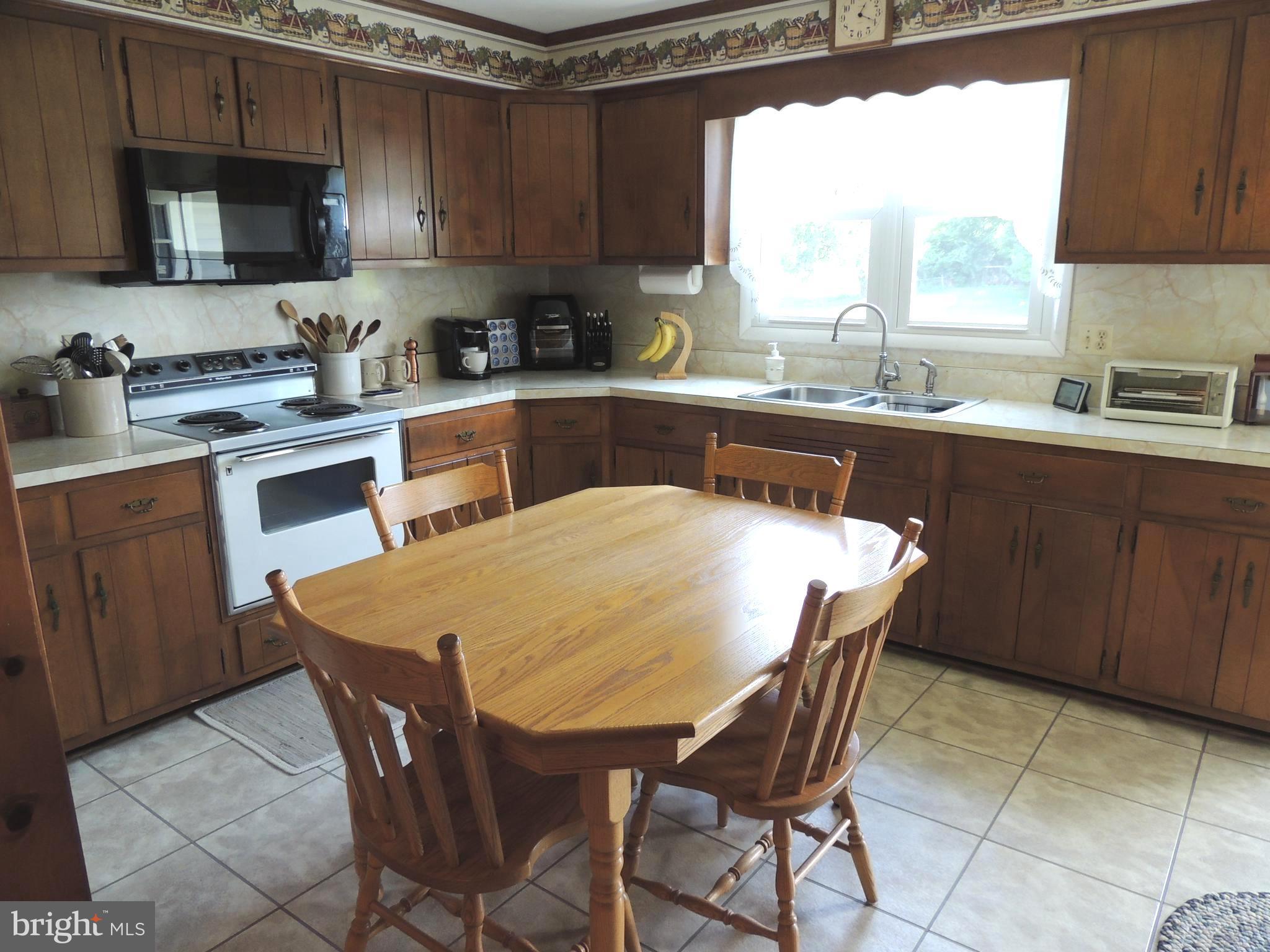 13730 Unionville Road Mount Airy, MD 21771 - Photo 8 of 30 a kitchen with a sink a microwave a stove and cabinets