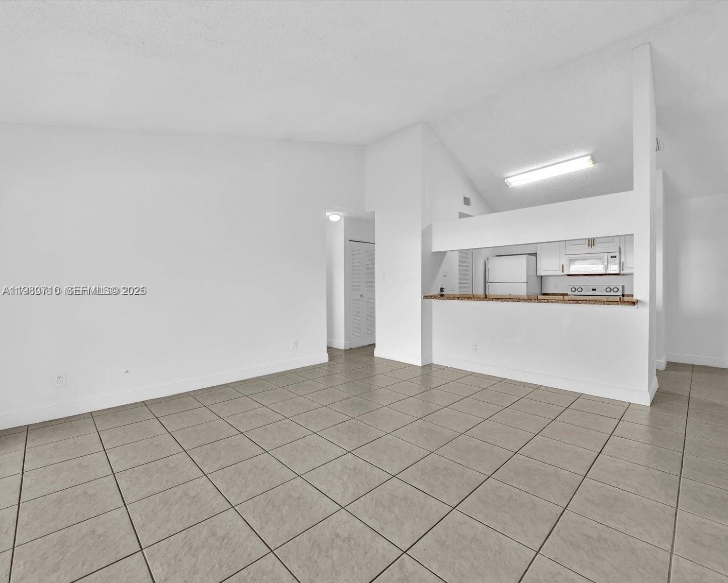 15770 Southwest 106th Terrace, Unit 303 Miami, FL 33196 - Photo 18 of 64 a view of a kitchen with a sink and an empty room