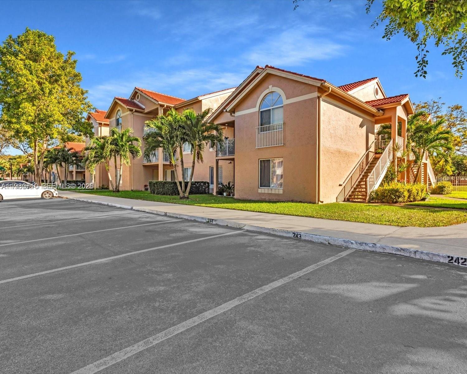 15770 Southwest 106th Terrace, Unit 303 Miami, FL 33196 - Photo 2 of 64 a front view of a house with a yard and garage