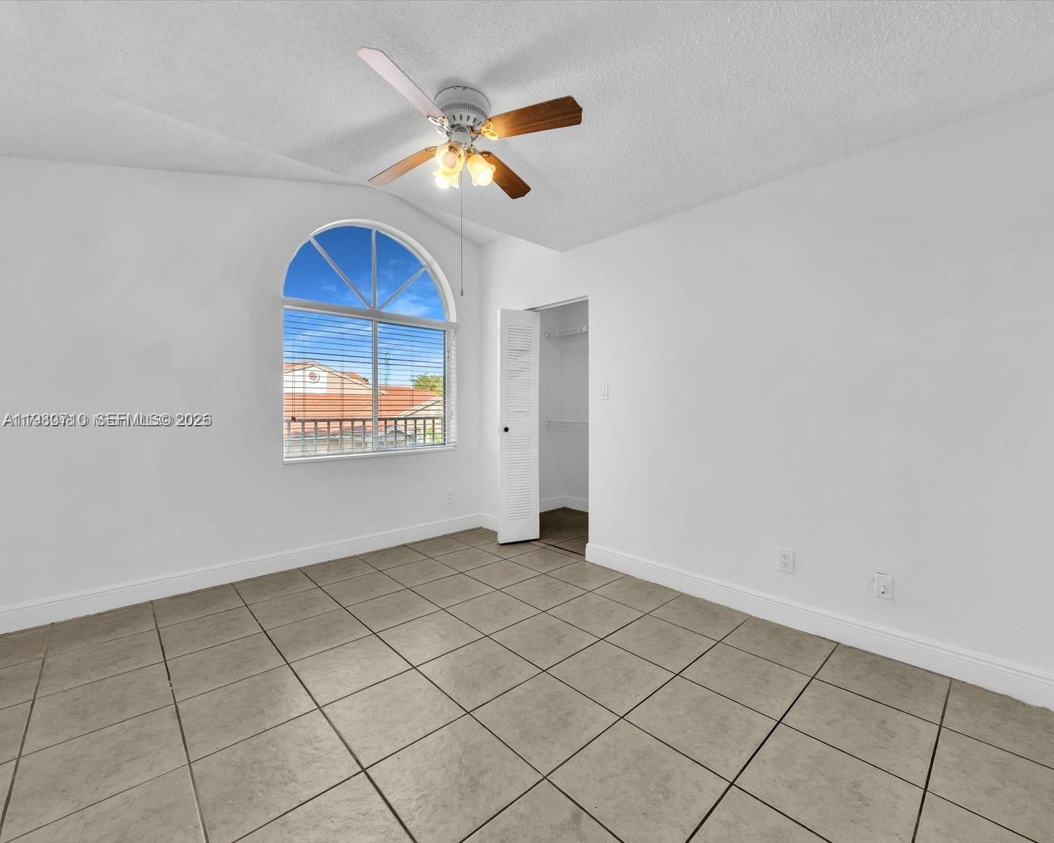 15770 Southwest 106th Terrace, Unit 303 Miami, FL 33196 - Photo 21 of 64 an empty room with windows and fan