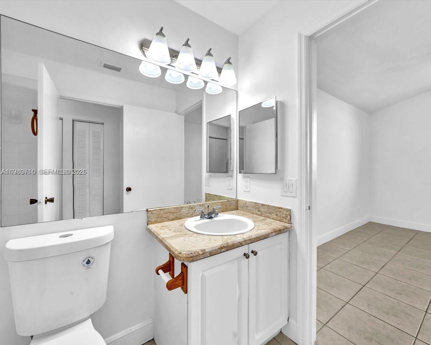 15770 Southwest 106th Terrace, Unit 303 Miami, FL 33196 - Photo 24 of 64 a bathroom with a granite countertop sink a large mirror and a