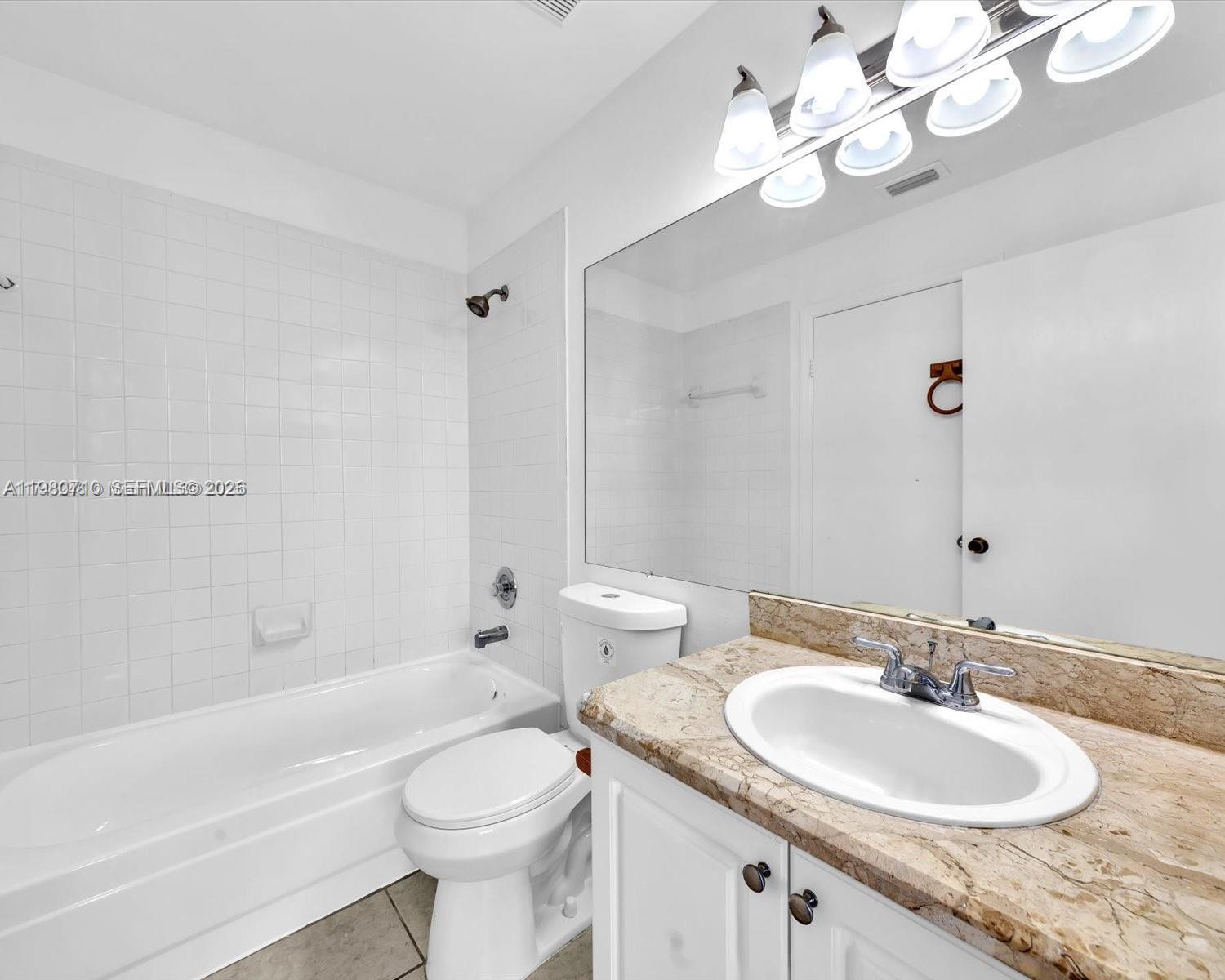 15770 Southwest 106th Terrace, Unit 303 Miami, FL 33196 - Photo 25 of 64 a bathroom with a granite countertop toilet sink and mirror