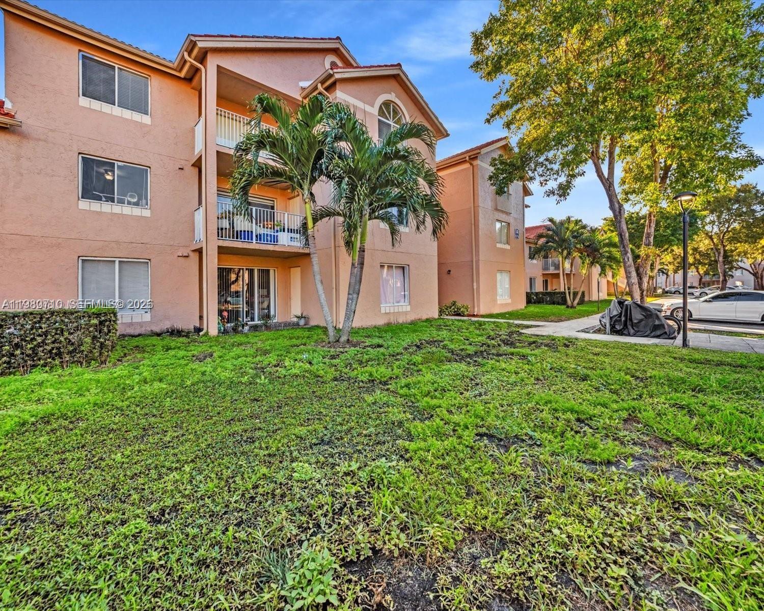 15770 Southwest 106th Terrace, Unit 303 Miami, FL 33196 - Photo 3 of 64 a front view of a house with garden