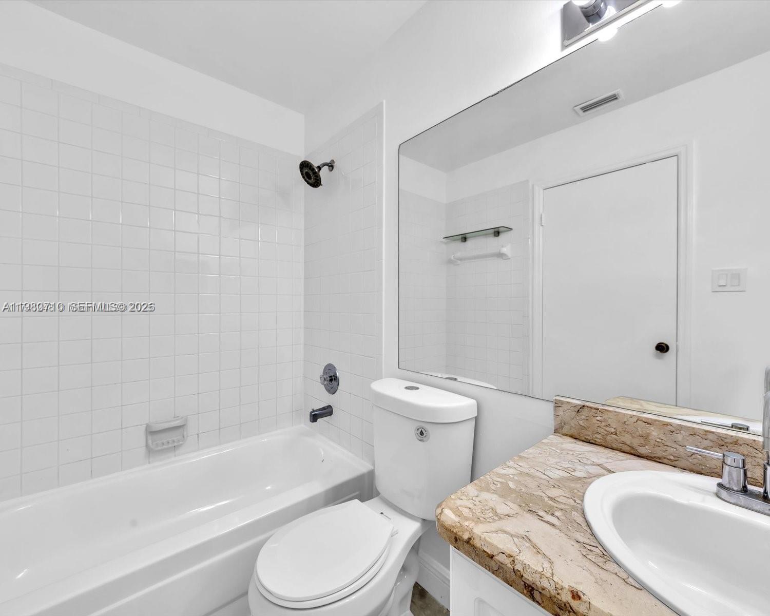 15770 Southwest 106th Terrace, Unit 303 Miami, FL 33196 - Photo 39 of 64 a bathroom with a granite countertop toilet sink and bathtub