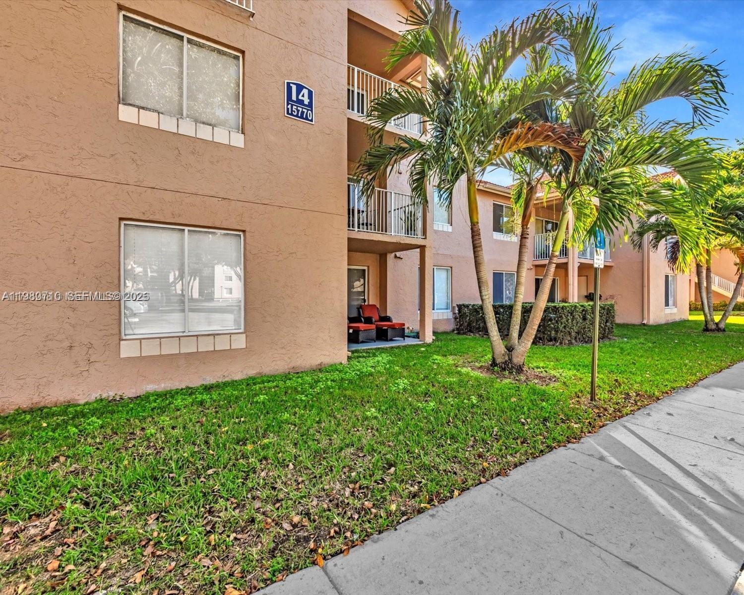 15770 Southwest 106th Terrace, Unit 303 Miami, FL 33196 - Photo 4 of 64 a view of a house with a small yard plants and palm trees