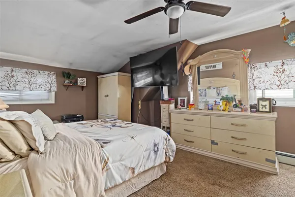 a bedroom with a bed and a mirror on the dresser