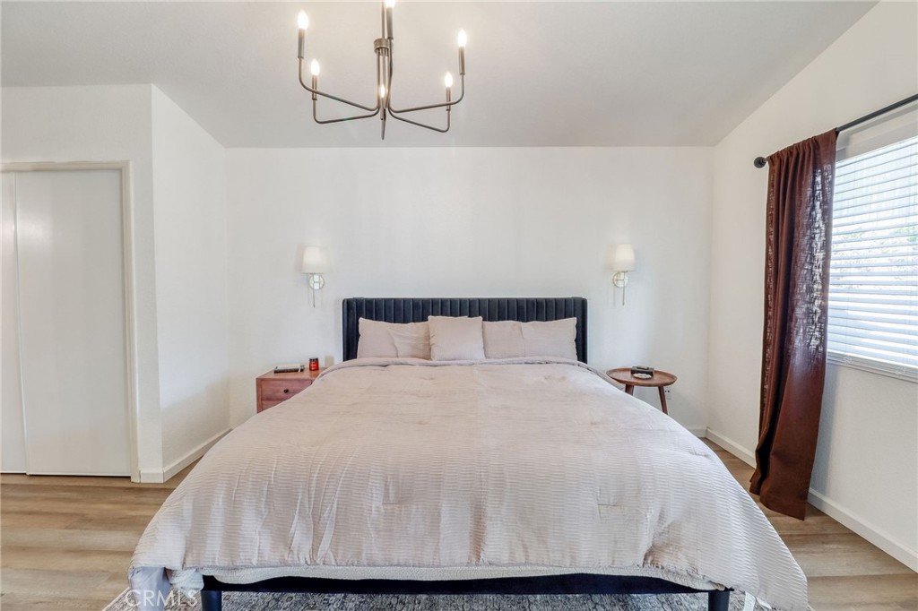 14235 Judy Ann Drive Riverside, CA 92503 - Photo 26 of 68 a large bed sitting in a bedroom next to a window and a wooden floor